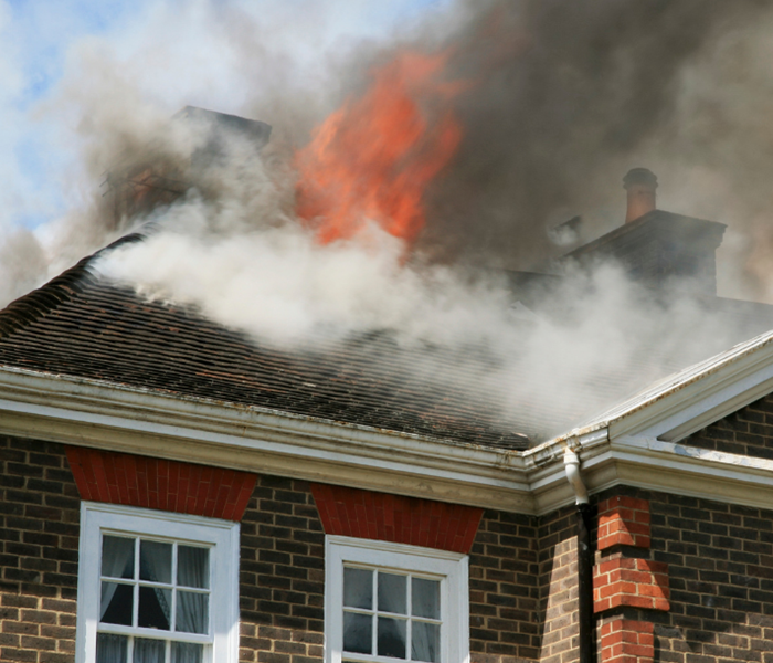 Brick Home with Flames Shooting up through the Roof.